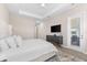 Bright main bedroom showcasing a TV, neutral walls, and exterior access to a private balcony at 17336 Sandpearl Rd, Venice, FL 34293