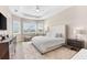 This spacious bedroom boasts tray ceilings, plentiful natural light, and a comfortable seating area at 17336 Sandpearl Rd, Venice, FL 34293