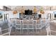 View of the pool bar, featuring stylish pendant lighting and multiple seating options in a covered, open air facility at 17336 Sandpearl Rd, Venice, FL 34293