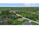 Aerial shot showcasing a home within a lush, green neighborhood and the surrounding treeline landscape at 1983 Longstroth Ave, North Port, FL 34288