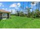 Expansive backyard featuring lush lawn, and a glimpse of the screened-in patio at 1983 Longstroth Ave, North Port, FL 34288