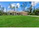 Charming single-story home with a well-manicured lawn and a two-car garage, surrounded by tall pine trees at 1983 Longstroth Ave, North Port, FL 34288