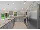Contemporary kitchen offering stainless appliances, gray cabinets, granite countertops, and backyard view at 1983 Longstroth Ave, North Port, FL 34288