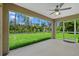 Enjoy the serene backyard view from this screened patio with neutral colors and ceiling fan at 1983 Longstroth Ave, North Port, FL 34288