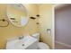 Cozy bathroom featuring a white vanity, round mirror, and yellow walls at 21524 Edgewater Dr, Port Charlotte, FL 33952