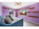 Cozy bedroom featuring a ceiling fan, shelves, and natural light from the windows at 21524 Edgewater Dr, Port Charlotte, FL 33952