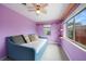 Cozy bedroom featuring a ceiling fan, shelves, and natural light from the windows at 21524 Edgewater Dr, Port Charlotte, FL 33952