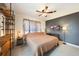 Bedroom featuring a king-sized bed, wood shelving, neutral colors, and a ceiling fan at 21524 Edgewater Dr, Port Charlotte, FL 33952
