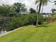 Backyard canal view featuring lush greenery, and a nearby dock at 2220 Broad Ranch Dr, Port Charlotte, FL 33948