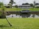 Boat dock with a boat lift on a canal, surrounded by lush green grass at 2220 Broad Ranch Dr, Port Charlotte, FL 33948