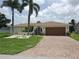 Charming single Gathering home with a two-car garage, beautiful lawn, and mature palm trees at 2220 Broad Ranch Dr, Port Charlotte, FL 33948