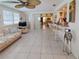 Open-concept living area with tile floors and bar seating to another area beyond at 2220 Broad Ranch Dr, Port Charlotte, FL 33948