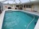 Relaxing screened in pool with blue tile, outdoor seating, and a nearby grill at 2220 Broad Ranch Dr, Port Charlotte, FL 33948