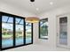 Bright dining area with modern light fixture and sliding glass doors overlooking the pool and canal at 245 Lido Dr, Punta Gorda, FL 33950