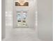 Light-filled foyer featuring pristine tile flooring, a contemporary chandelier, and modern accents at 245 Lido Dr, Punta Gorda, FL 33950