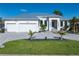Beautiful home featuring a three-car garage, pristine landscaping, and a modern architectural style at 245 Lido Dr, Punta Gorda, FL 33950