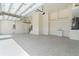 View of a spacious two car garage with epoxy flooring, water heater, and storage space at 245 Lido Dr, Punta Gorda, FL 33950