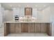 Kitchen island featuring wooden cabinetry, marble countertop, dual sinks, and pendant lighting at 245 Lido Dr, Punta Gorda, FL 33950