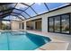 Screened-in pool area with a tanning ledge and view to the kitchen at 245 Lido Dr, Punta Gorda, FL 33950
