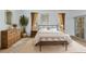 Charming bedroom with neutral tones, decorative art and curtains, a comfortable bed, and bench at the foot of the bed at 24504 Buckingham Way, Punta Gorda, FL 33980