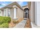 Inviting entrance featuring a screened-in porch, decorative columns, and manicured landscaping at 24504 Buckingham Way, Punta Gorda, FL 33980