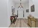 Bright foyer with stylish decor, featuring wood floors, decorative tables and arch window above door at 24504 Buckingham Way, Punta Gorda, FL 33980