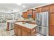 Modern kitchen with stainless steel appliances, wooden cabinets, and a center island at 24504 Buckingham Way, Punta Gorda, FL 33980