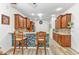 Kitchen featuring wooden cabinetry, a breakfast bar, and stylish backsplash at 24504 Buckingham Way, Punta Gorda, FL 33980
