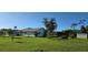 Exterior view of a well-maintained home with mature trees and a spacious lawn at 39 Norman St, Port Charlotte, FL 33954