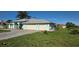 Charming facade featuring a three car garage, brick driveway, lush front yard and manicured landscaping at 39 Norman St, Port Charlotte, FL 33954