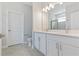 Bright bathroom with double vanity, framed mirror, modern lighting, and wood-look tile flooring at 4627 Schoen St, North Port, FL 34291
