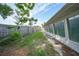 An outdoor space featuring a simple lawn, a wood fence, and a view of the house with multiple windows at 475 Whippoorwill Dr, Venice, FL 34293