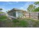 A home's backyard including a sun room, grassy area and wooden fence at 475 Whippoorwill Dr, Venice, FL 34293