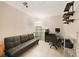Office space with a black futon, shelving, desk, and a chair on a tiled floor at 475 Whippoorwill Dr, Venice, FL 34293