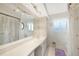 Bathroom featuring an extra-long vanity, large mirror and shower curtain in a floral design at 475 Whippoorwill Dr, Venice, FL 34293