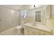 Bathroom with a shower-tub combo with sliding glass door, toilet, and vanity with sink at 475 Whippoorwill Dr, Venice, FL 34293