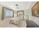 Comfortable bedroom featuring tile floors, a ceiling fan, and a window with curtains at 475 Whippoorwill Dr, Venice, FL 34293
