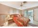 Relaxing bedroom with tile flooring, a ceiling fan, and sliding door access to lanai at 475 Whippoorwill Dr, Venice, FL 34293