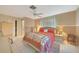 Comfortable bedroom featuring a ceiling fan, tile floors, and a decorative bedspread at 475 Whippoorwill Dr, Venice, FL 34293