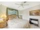 Inviting bedroom with tile floors, ceiling fan, and a window with light-filtering curtains at 475 Whippoorwill Dr, Venice, FL 34293