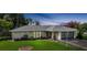 Single-story home with a well-manicured lawn, plants, and attached garage at 475 Whippoorwill Dr, Venice, FL 34293
