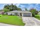 Well-kept single-story home with a neat lawn, stamped concrete driveway, and attached garage at 475 Whippoorwill Dr, Venice, FL 34293