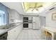Functional kitchen featuring white cabinetry, neutral countertops, and tile flooring at 475 Whippoorwill Dr, Venice, FL 34293