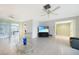 Bright living room with tile flooring, ceiling fan, and sliding glass doors to the lanai at 475 Whippoorwill Dr, Venice, FL 34293