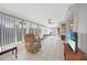 A sun filled room with tile floors, ceiling fan and access to the kitchen at 475 Whippoorwill Dr, Venice, FL 34293