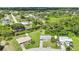 An aerial view shows a charming neighborhood with lush greenery and waterfront homes near a canal at 769 Crestview Nw Cir, Port Charlotte, FL 33948