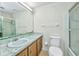 A well-lit bathroom with a shower-tub combo, toilet, and sink with a long mirror and marble-style countertop at 769 Crestview Nw Cir, Port Charlotte, FL 33948