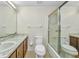 A spacious bathroom featuring a shower-tub combo, toilet, and sink with a large mirror and marble-style countertop at 769 Crestview Nw Cir, Port Charlotte, FL 33948