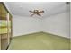 An empty bedroom featuring neutral carpet, ceiling fan, large sliding door, and backyard providing great light at 769 Crestview Nw Cir, Port Charlotte, FL 33948