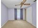 A bedroom featuring neutral carpet, ceiling fan and curtains providing a view of the natural light outdoors at 769 Crestview Nw Cir, Port Charlotte, FL 33948